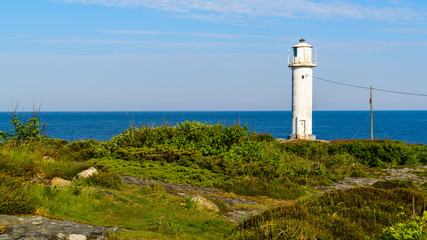 Fototapeta na wymiar The Subbe lighthouse in southern Varberg, Sweden, with surrounding landscape on a sunny and calm morning.