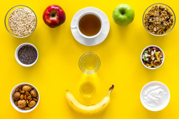 Layout of products for healthy and hearty breakfast. Fruits, oatmeal, yogurt, nuts, crispbreads, chia on yellow background top view