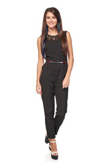 Happy woman in black jumpsuit standing relaxed smiling at camera, full length portrait