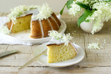 Lemon pie with a glaze of sugar and elderflower syrup, decorated with elderberry flowers. Rustic style.