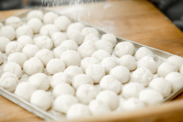 Close-up view on the raw daugh balls ready for baking buns on the tray
