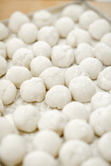 Close-up view on the raw daugh balls ready for baking buns on the tray