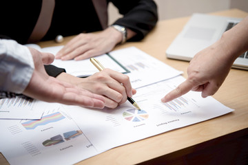 Hands of business people working with papers at meeting together.