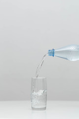 Water is poured in a glass in a studio