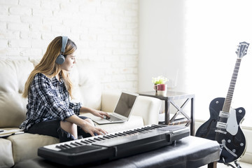 Female musician composing music at home