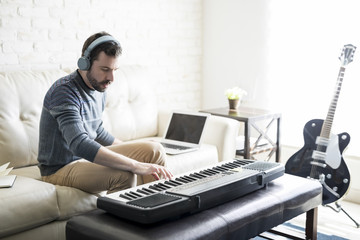 Man composing a song with electric piano