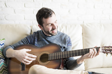 Man enjoying playing guitar at home