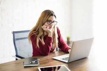 Thoughtful woman using laptop