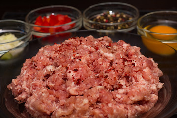 Raw meat beef in a plate with spices on a black cutting board. Fresh stuffing.