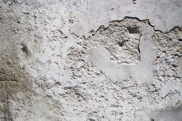 Texture of an old white concrete wall with small holes
