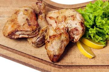 roasted chiken parts with lemon salad and tomatoes on cuttung board isolated on white background