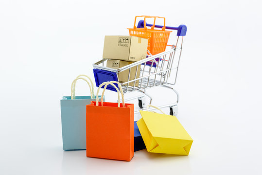 Shopping addiction, shopping lover or shopaholic concept : Paper boxes / cartons and small toy shopping cart, on white background. Many people / consumers or buyers addicted to buy unnecessary things.