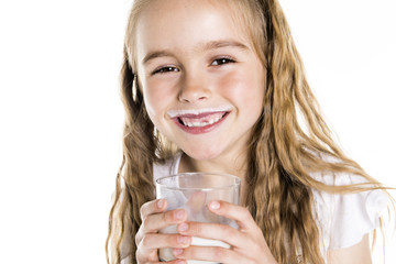 Portrait of a cute 7 years old girl Isolated over white background with milk glass