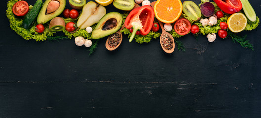 Healthy food. Vegetables and fruits On a black wooden background. Top view. Copy space.