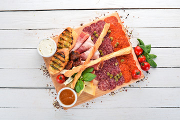 Meat cut and cold snacks. Italian cuisine. On a wooden background. Top view. Copy space.