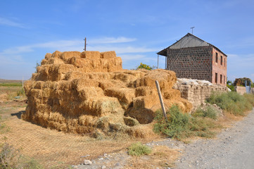 Bales of hay in the yard of the house. Lusarat, Armenia