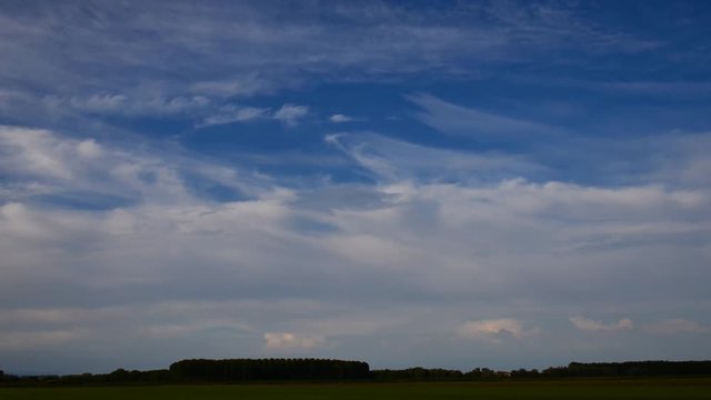 field of green rise and cloudy sky