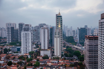 Fototapeta na wymiar View of the city skyline in the early morning light with houses and buildings under cloudy skies in the city of São Paulo. The gigantic city, famous for its cultural and business vocation.