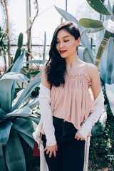 Photo Session of a beautiful young girl in blooming magnolia, cactus and other vegetation.