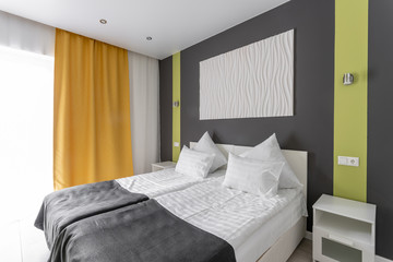 daylight morning. Hotel standart room. modern bedroom with white pillows. simple and stylish interior.