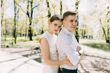 Beautiful young couple in the Park on a Sunny day, loving and happy. Walk and laugh together. Pre-wedding shooting in nature. Elegant style in clothes like celebrities