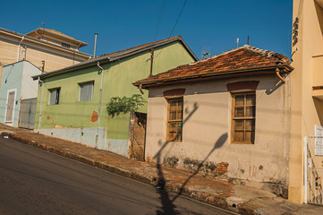 Working-class shabby colored houses in an empty street on a sunny day at São Manuel. A cute little town in the countryside of São Paulo State. Southeast Brazil.