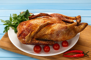 Roast duck on a white platter. Ready to serve poultry. Table setting. Roasted duck on the grill.