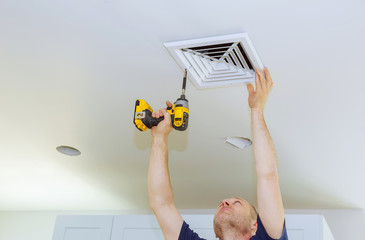 Man installing of HVAC, heating ventilating and cooling after replacing the air filter.