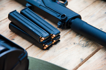 Gun with ammunition on wooden background