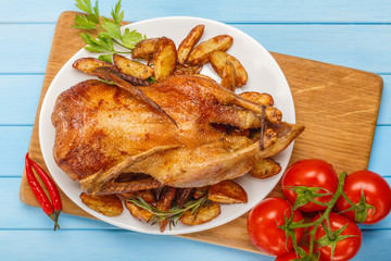 Roast duck on a white platter. Ready to serve poultry. Table setting. Roasted duck on the grill.