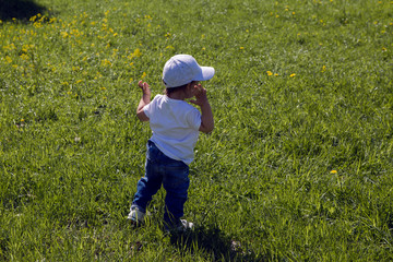 child in a white cap runs