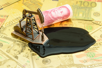 Petroleum, petrodollar and crude oil concept : Pump jack and China CNY yuan on US USD dollar notes, depicts the money received or earned from sales after investment in the development of oil industry.