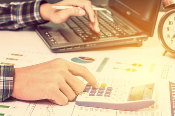 Insight financial report analysis concept : Businessman or CFO sees, calculates and analyses a firm annual / summary reports with graphs and charts on a table in the office before public disclosure.