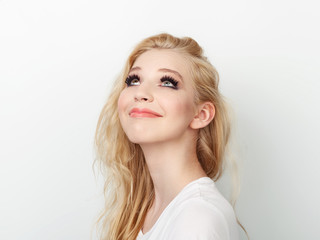 Beauty portrait of model with trendy natural make-up looking up. Fashion shiny highlighter on skin, sexy gloss lips make-up.