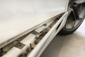 white broken assorted dusty car stands in the garage