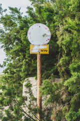 Sign writtin in hebrew among green three