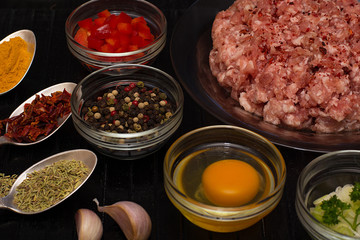 Raw meat beef in a plate with spices on a black cutting board. Fresh stuffing.