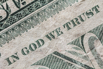 A detail of a one dollar bill. We can read the famous sentence 