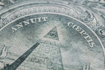 A detail of a one dollar bill. It is seen the famous "illuminati" triangle, with the eye that can see everything. It is an old note.