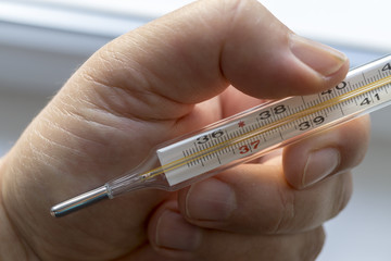 Close Up Image Of Thermometer Showing High Temperature.Human hand holding medicine healthcare thermometer