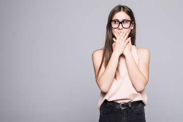 Pretty girl covering her mouth over a grey background