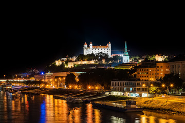 Fototapeta na wymiar Bratislava, Slovakia May 23, 2018: Bratislava at night, with the city lights reflected in the Danube river. On the top hill stands the Bratislava Castle built in the 9th century.