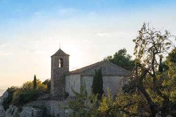 Fototapeta premium View of the Romanesque church of Santa Maria de Siurana at sunset in Siurana de Prades, Tarragona, Spain. Copy space for text.
