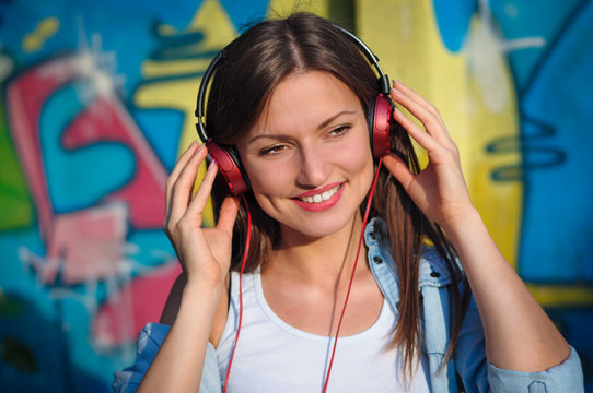 Beautiful woman listening to music on red headphones