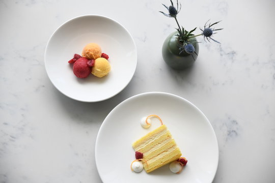 Sorbet With Raspberries And Yellow Sponge Cake Slice On Plates