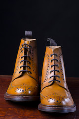 Footwear Compositions Made Up of Mens Fashionable Tanned Brogues Boots Isolated Over Black