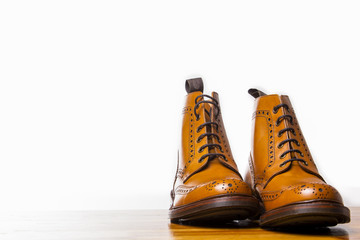 Footwear Concepts.Pair of High Gentleman Tanned Brogues Boots. Isolated Over White Background.