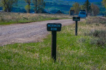 Close up of wooden sign located at one side of rocky road leading to the Grand Teton National Park, Wyoming in a gorgeous sunny day
