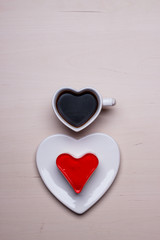 Heart shaped coffee cup and cake on wood surface