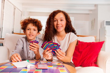 Naklejka premium Brother and sister playing card games indoors